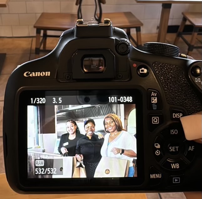 a camera with a screen showing a group of women