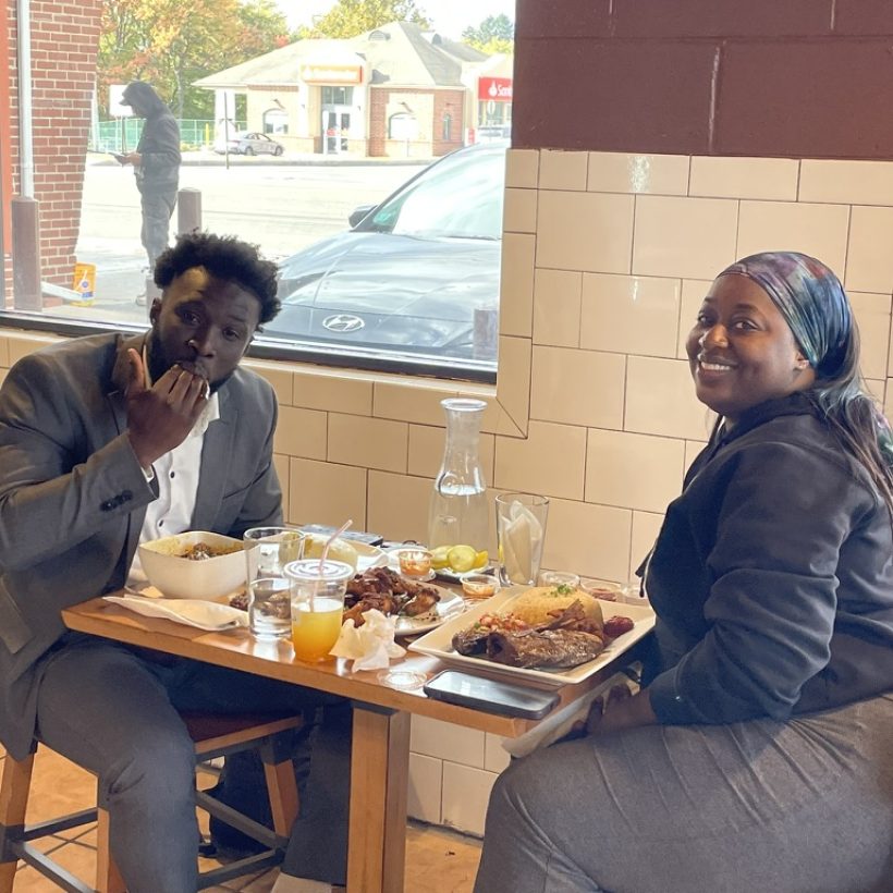 a man and woman sitting at a table with food