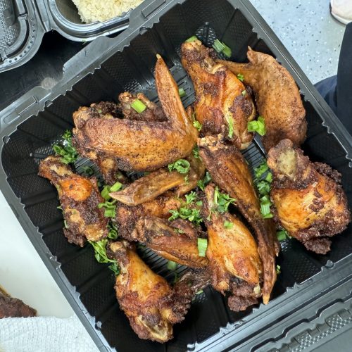 a black container with chicken wings