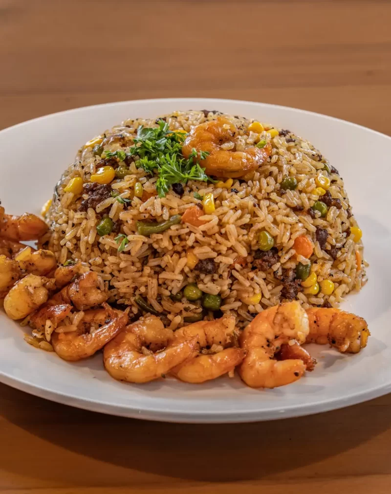 a plate of rice with shrimp and vegetables