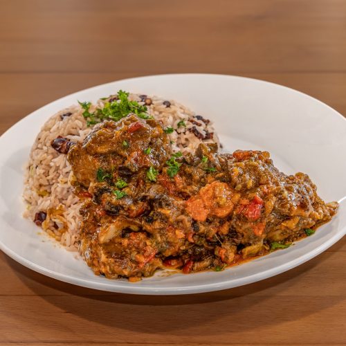 a plate of oxtail and rice on a table