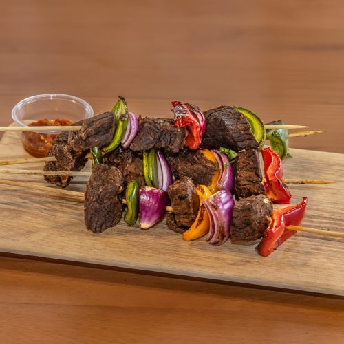 meat on skewers on a wooden board